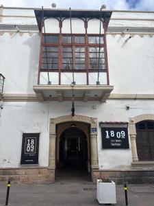 a building with a balcony on top of it at Distrito Hostal Y Gatro bar in Sucre