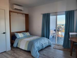 ein Schlafzimmer mit Bett und Blick auf einen Balkon in der Unterkunft Luxury studio with incredible bay view in Birch Bay