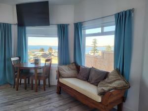 ein Wohnzimmer mit einer Couch und einem Tisch und einem Fenster in der Unterkunft Luxury studio with incredible bay view in Birch Bay