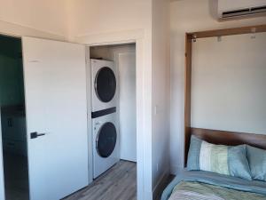 ein Schlafzimmer mit einem Bett sowie einer Waschmaschine und einem Trockner in der Unterkunft Luxury studio with incredible bay view in Birch Bay