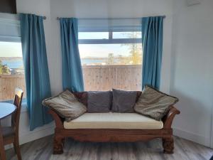 eine Couch vor einem Fenster mit blauen Vorhängen in der Unterkunft Luxury studio with incredible bay view in Birch Bay + 11 Fotos
