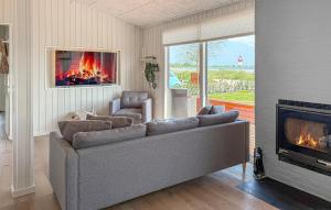a living room with a couch and a fireplace at 3 Bedroom Amazing Home In Sjølund in Binderup Strand