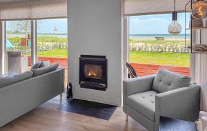 a living room with two couches and a fireplace at 3 Bedroom Amazing Home In Sjølund in Binderup Strand +19 photos