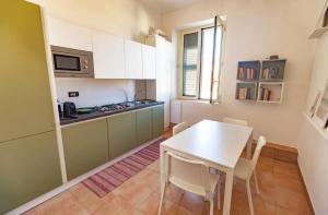 a kitchen with a white table and a table and chairs at Luxury Suite Vitruvio 55 in Formia