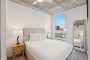 a bedroom with a white bed and a large window at Placemakr Downtown Phoenix in Phoenix +74 photos