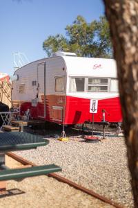 a red and white trailer is parked on the tracks at Shasta Trailer- Vintage Charm, Modern Comfort Pool in Yucca Valley