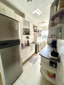 Una cocina con gabinetes blancos y un refrigerador de acero inoxidable. en Apartment in Ananindeua, en Ananindeua