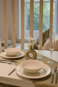 a table with plates and bowls and glasses on it at Royal Oakwood Studio 1 Bed Brighton Sleeps 2 in Brighton & Hove