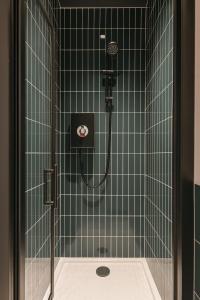 a bathroom with a shower with green tiles at Royal Oakwood Studio 1 Bed Brighton Sleeps 2 in Brighton & Hove