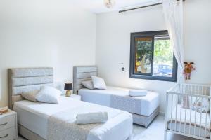 a bedroom with two beds and a crib at Cosy Apartment - Calm & Central, Parking, Garden in Agadir