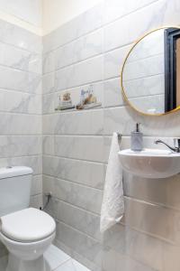a white bathroom with a toilet and a mirror at Cosy Apartment - Calm & Central, Parking, Garden in Agadir