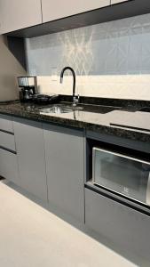 a kitchen with a sink and a microwave at Studios Gago 167 in Suzano