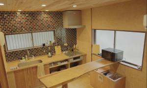 eine Küche mit einer Spüle und einer Theke mit einer Mikrowelle in der Unterkunft konatoko in Wakayama