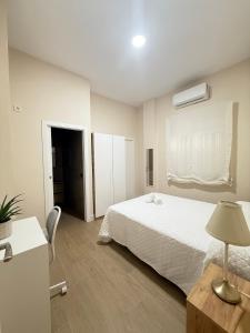 een slaapkamer met een bed en een tafel met een lamp bij Apartamento Orilla de Triana Luxury in Sevilla