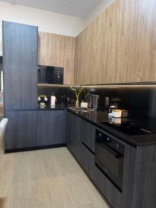 een keuken met zwarte werkbladen en houten kasten bij Apartamento Orilla de Triana Luxury in Sevilla