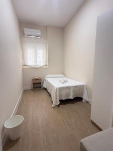 een witte kamer met een bed en een raam bij Apartamento Orilla de Triana Luxury in Sevilla