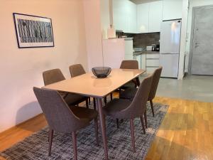 Una mesa de comedor con sillas y una cocina. en Skopje Centre APT near Vodno with Garage Parking, en Skopje