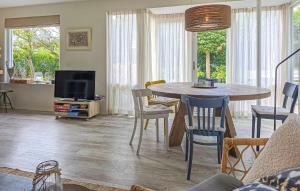 ノールトウェイケルハウトにある2 Bedroom Beautiful Home In Noordwijkerhoutのテーブルと椅子とテレビのあるリビングルーム