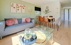 a living room with a blue couch and a table at Beautiful Home In Heinkenszand With Wifi in Graszode