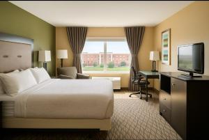 een hotelkamer met een bed en een flatscreen-tv bij Wingate by Wyndham Fort Saskatchewan in Fort Saskatchewan