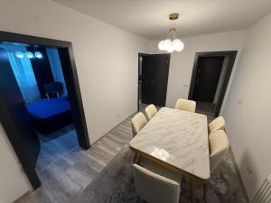 a dining room with a white table and chairs at Happy House in Craiova +5 photos