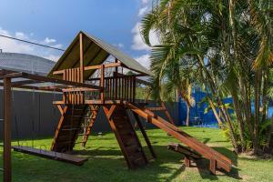 a wooden playground with a slide and a tree at Hotel Deville Prime Porto Alegre in Porto Alegre