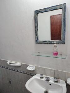un baño con lavabo y espejo en Cabaña La Tere, en La Porteña