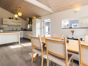a kitchen and dining room with a wooden table and chairs at 4 star holiday home in Karrebæksminde in Enø By +19 photos