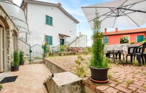 a patio with a table and an umbrella at 1 Bedroom Stunning Apartment In Masso in Castiglione Chiavarese +8 photos