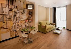 a living room with a table and a couch at Apartamentos Suites Oficentro Deluxe in Málaga