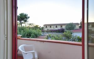 ein weißer Stuhl auf einem Balkon mit Blick auf einen Garten in der Unterkunft Amazing Apartment In Santa Maria Di Castell in Santa Maria di Castellabate