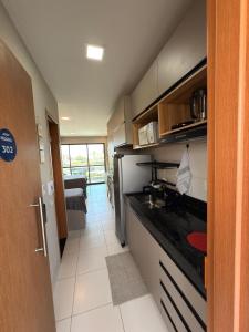 FLAT DE LUXO vista piscinas, Praia de Muro Alto - Malia Beach في إيبوجوكا: مطبخ مع حوض وطاولة عمل