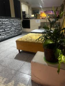 a living room with a yellow couch and a plant at Hotel Aldeano ll in Buenos Aires