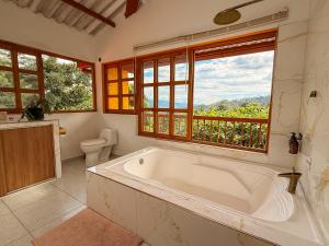 a large bath tub in a bathroom with a window at El Nido Andino in La Mesa +43 photos