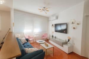 a living room with a blue couch and pink chairs at Apto La Justicia in Jerez de la Frontera