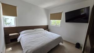 una camera da letto con un letto e una TV a schermo piatto di Paraíso Liverte 203 a Cancún Altre 15 foto