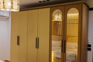 ein Holzschrank mit Glastüren in einem Schlafzimmer in der Unterkunft شقة فندقية فاخرة شارع جيهان الرئيسي بجوار النيل و جامعه المنصوره in Mansoura