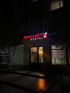 a restaurant with a neon sign in the dark at Rakhat66 in Astana
