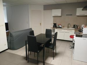 a kitchen with a black table and chairs in it at Studio familial avec terrasse, proche de Metz in Rémilly +8 photos