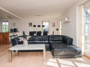 a black leather couch in a living room with a table at Panoramic Golf View Retreat - By Traum Ferienwohnungen in Sønderby +46 photos