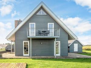 a house with a gambrel roof with a balcony at 5 star holiday home in Rømø in Sønderby