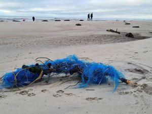 a blue net on a beach with people in the background at 6 person holiday home in Ulfborg-By Traum in Ulfborg