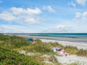 eine Gruppe Kinder, die im Sand am Strand sitzen in der Unterkunft 8 person holiday home in Glesborg in Glesborg