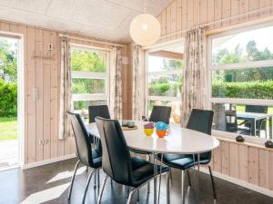 a dining room with a table and chairs and windows at Modern Retreat near Vadehavet - By Traum Ferienwohnungen in Rømø Kirkeby