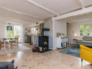 Una sala de estar con chimenea y una mesa. en 5 person holiday home in Lundby, en Lundby