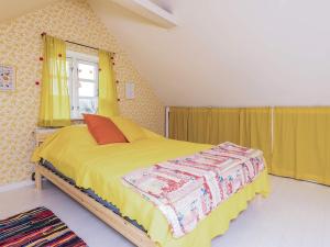 a bedroom with a bed with yellow sheets and a window at 5 person holiday home in Lundby in Lundby