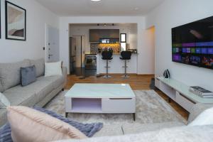 a living room with a couch and a tv at Premium Luxury 2-Bedroom Apartment in Tatu City