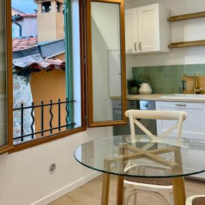 a glass table and a chair in a kitchen at La Résidence du Vieux Château - Splendide Vue Mer in Menton