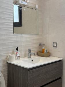 a bathroom with a sink and a mirror at Studio Ngor, route de l'aéroport in Ngor