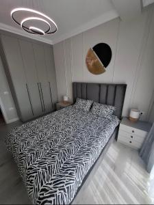 ラダウツィにあるSky Towers Apartmentのベッドルーム1室(ベッド1台、白黒の掛け布団付)